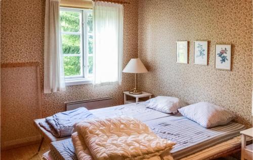 een slaapkamer met een bed en een raam bij 3 Bedroom Nice Home In Norrtlje in Norrtälje