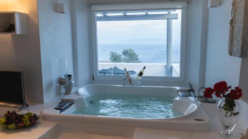 a large bath tub in a room with a window at Villa Delilah - Paradise Estate Mykonos - Views, Party, Memories 2026 in Paraga