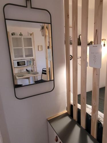 een spiegel in een kamer met een tafel en een magnetron bij Appart cocooning proche centre avec Parking in Hyères