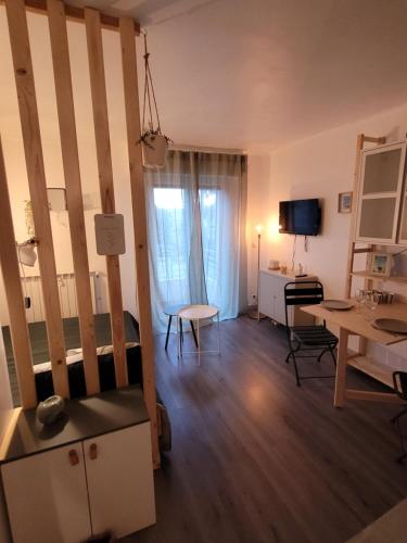 een kleine woonkamer met een tafel en een bureau bij Appart cocooning proche centre avec Parking in Hyères