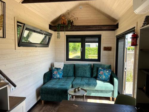 a living room with a couch in a tiny house at Tiny House Lovely Sunshine in Giethoorn