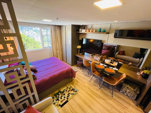 a bedroom with a large bed and a dining room at Studio luxo Granja Brasil Green Mountain flat - Itaipava in Itaipava