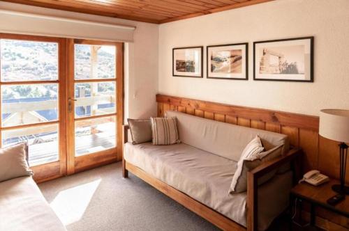 sala de estar con sofá y ventana en Departamento Hosteria del Cerro en San Carlos de Bariloche
