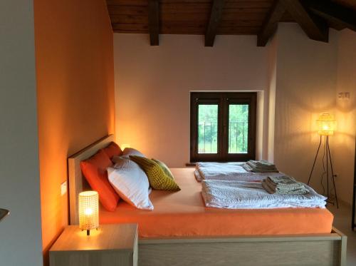 1 dormitorio con 1 cama con pared de color naranja en Al Borgo Affittacamere en Venzone