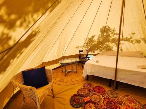a bedroom in a tent with a bed and a table at Tende Glamping Vista Mare Marina Serra in Marina Serra
