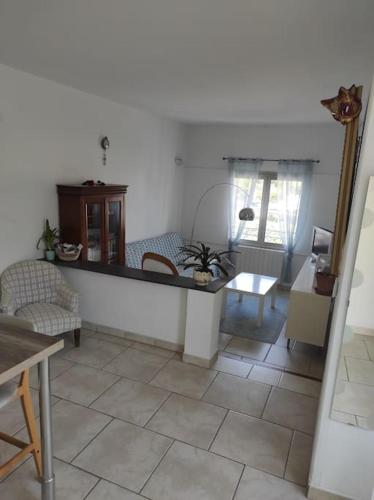 ein Wohnzimmer mit Fliesenboden und einem Tisch in der Unterkunft Joli appartement avec cour privé à 150m de la mer in Sanary-sur-Mer