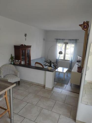 - un salon doté de carrelage et d'une table dans l'établissement Joli appartement avec cour privé à 5 minutes à pied de la plage, à Sanary-sur-Mer