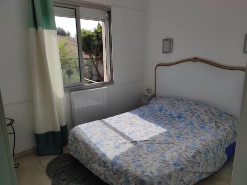 une chambre avec un lit et une fenêtre dans l'établissement Joli appartement avec cour privé à 5 minutes à pied de la plage, à Sanary-sur-Mer