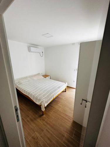 a small bedroom with a bed in a room at Apartmani Neo in Sutomore