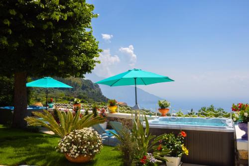 ein Pool mit Sonnenschirmen und Pflanzen im Hof in der Unterkunft Villa Veronica Luxury Suite in Amalfi coast in Piano di Sorrento