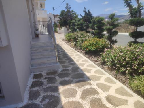 una escalera que conduce a una casa con flores en Bee life apts, Sweet house, en Kokkinos Pirgos