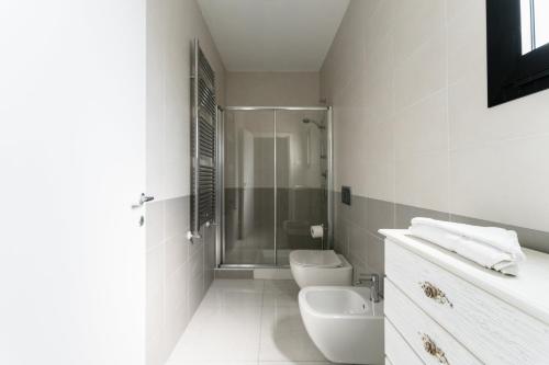 e bagno con doccia, servizi igienici e lavandino. di Geovillage Green Residence a Olbia