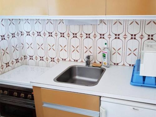 - une cuisine avec un évier et un comptoir blanc dans l'établissement Studio cosy à 300m de la mer avec parking privatif - Argelès sur Mer - FR-1-388-151, à Argelès-sur-Mer