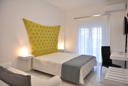 Ilion Luxury Studios في أسبروبالتا: غرفة نوم بسرير و اللوح الأمامي الأصفر