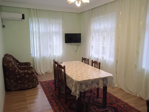 uma sala de jantar com uma mesa e cadeiras e uma televisão em Mountain view Villa em Gabala