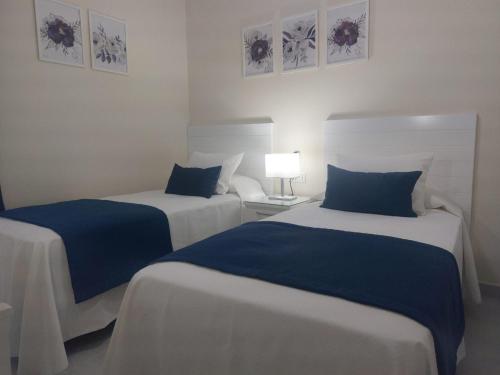 2 camas en una habitación de color azul y blanco en La Palma en Tarajalejo