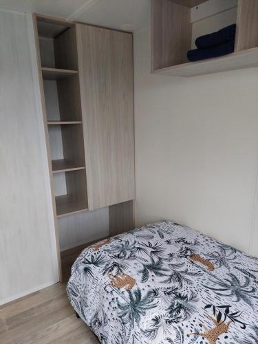 a bedroom with a bed and a book shelf at Chalet Goudrenette in Hengstdijk
