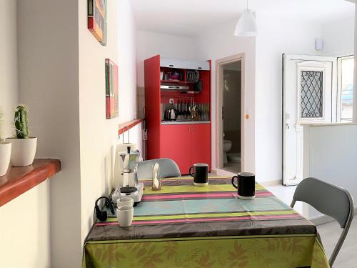 a kitchen with a table and a red cabinet at Alma Resorts Studio in Rhodes Town