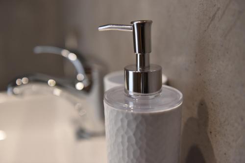 un primer plano de un dispensador de jabón en el lavabo del baño en Ilion Luxury Studios, en Asprovalta