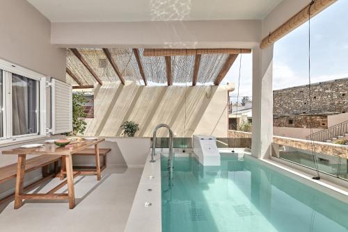 Melidhónionにある2 bedroom Villa with heated swimming pool-Spa whirlpool-BBQ!のスイミングプールとテーブル付きの家