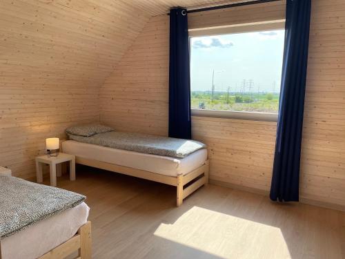 um quarto com 2 camas individuais e uma janela em PoProstuDomki em Niechorze
