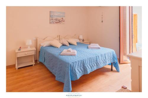 a bedroom with a blue bed with two towels on it at Ancóramare in Stintino
