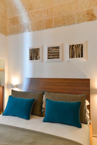 a bedroom with a large bed with blue pillows at B-Welcome Rooms of Charme e Relax in Polignano a Mare