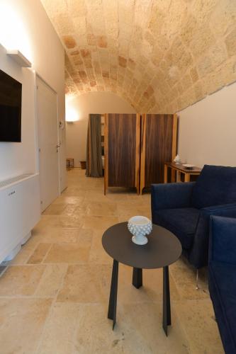 a living room with a blue couch and a table at B-Welcome Rooms of Charme e Relax in Polignano a Mare