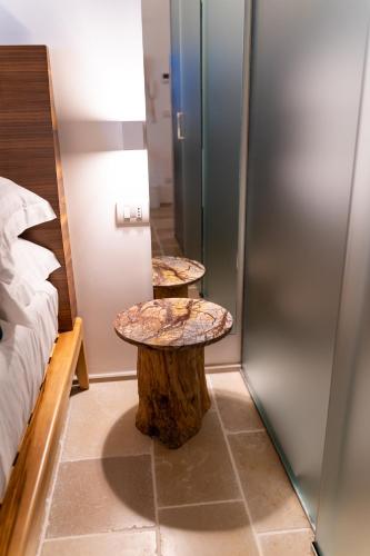 a room with two tables on a tree stump next to a bed at B-Welcome Rooms of Charme e Relax in Polignano a Mare