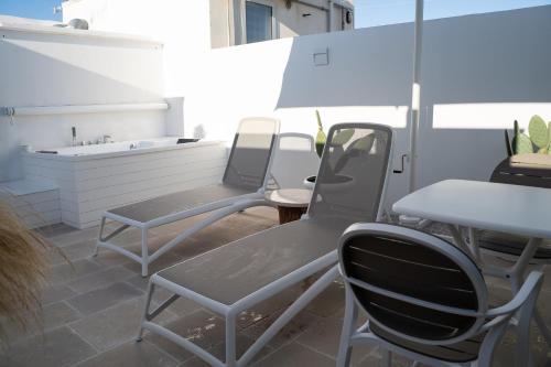 two chairs and a table on a patio at B-Welcome Rooms of Charme e Relax in Polignano a Mare