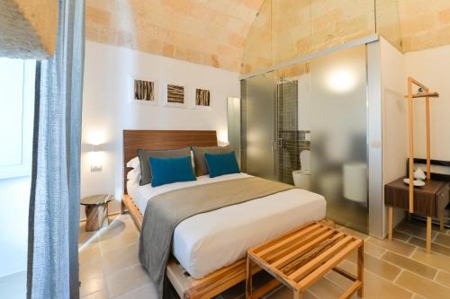 a bedroom with a large bed with blue pillows at B-Welcome Rooms of Charme e Relax in Polignano a Mare