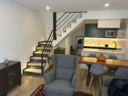 a living room with a staircase and a table and chairs at Palmela cozy in Palmela