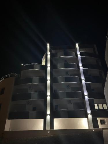 a tall building with lights on it at night at Apartmani Sunce in Bar