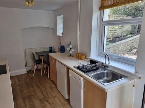 Lydbrook的住宿－Cheerful two bedroom cottage in the Forest of Dean，厨房设有水槽和窗户。