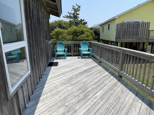 2 sillas azules sentadas en una terraza de madera en Gray Eagle House 58202, en Hatteras