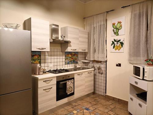 奇尼斯的住宿－La Sicilia in casa，厨房配有冰箱和炉灶。 顶部烤箱