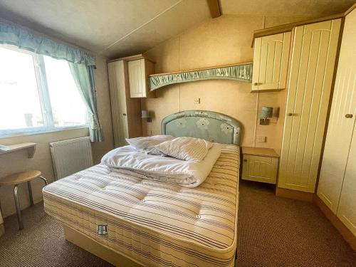 a small bedroom with a bed in the corner at 4 Berth Nearby Hunstanton Beach In Norfolk Ref 13018l in Hunstanton