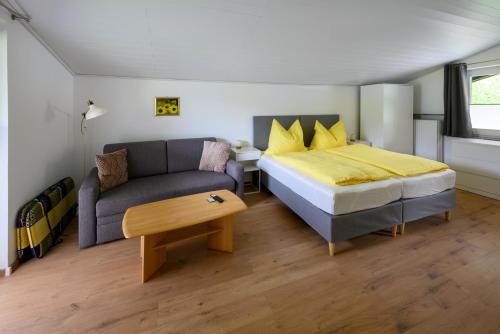 um quarto com uma cama e um sofá em Am Randersberg - Wohnung Nr 1 em Grossgmain