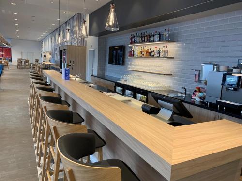 a bar in a restaurant with a row of chairs at Holiday Inn Express - Aarburg - Oftringen by IHG in Oftringen