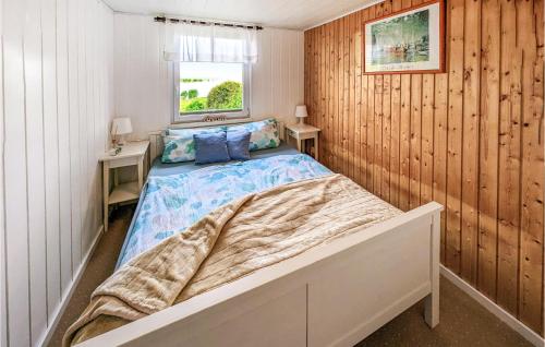 a bedroom with a bed in a room with wooden walls at Nice Home In Usedom With Kitchen in Wilhelmshof
