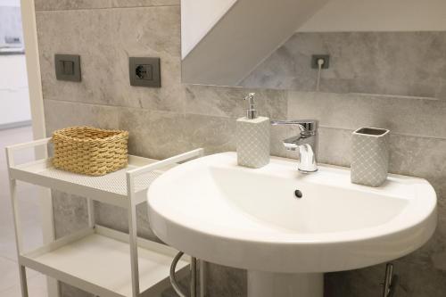 een badkamer met een witte wastafel en een spiegel bij Sorso per passione in Sorso