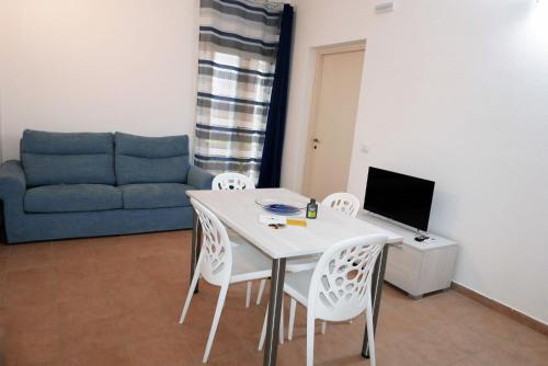 uma sala de estar com uma mesa e cadeiras e um sofá em La Torretta em Piombino