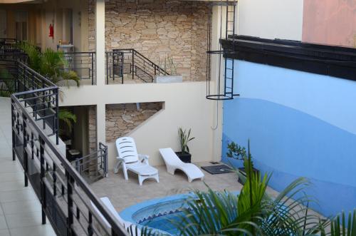 un patio con 2 sillas y una piscina en Hotel Suite & Spa Verdesolaro en Villa Elisa