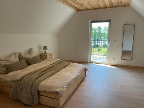 a bedroom with a large bed with a large window at CreamHouse in Międzyzdroje