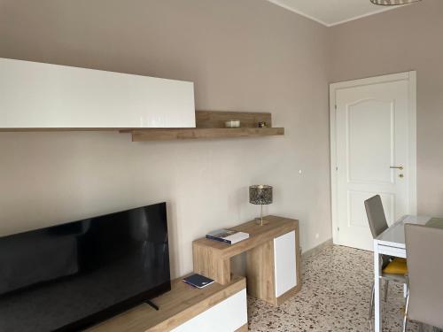 a living room with a flat screen tv and a table at Rosa vacanza e o lavoro in Nichelino