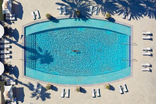 an overhead view of a swimming pool with chairs and palm trees at The Ritz-Carlton, Grand Cayman in George Town