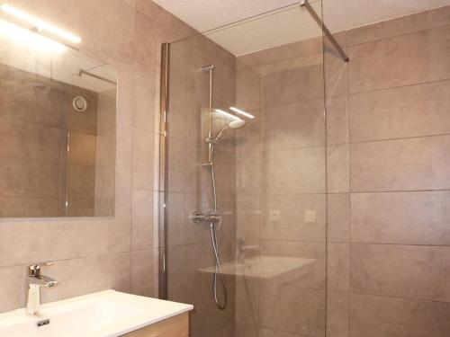 une douche avec une porte vitrée à côté d'un lavabo dans l'établissement Appartement confort 2P, 6 pers, cœur de station, accès direct pistes, cheminée, WiFi, TV, balcon ouest - FR-1-322-297, aux Orres