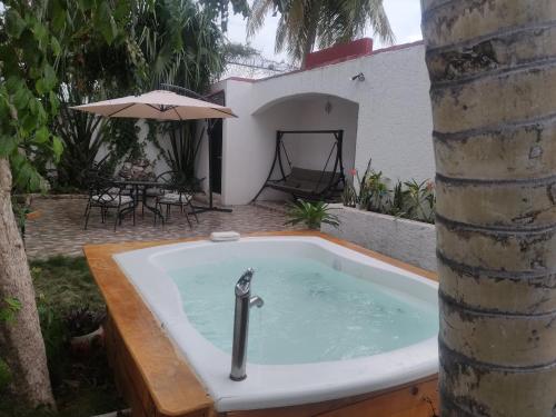 a jacuzzi tub in a yard with an umbrella at Villa Tulipan (Downtown of Cancun) in Cancún