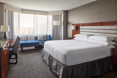 a hotel room with a large bed and a desk at Crystal Gateway Marriott in Arlington