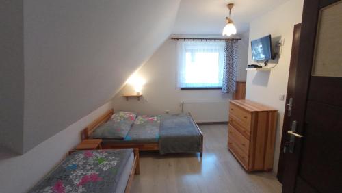 Cette petite chambre comprend 2 lits et une fenêtre. dans l'établissement Noclegi u Bartka, à Sromowce Niżne